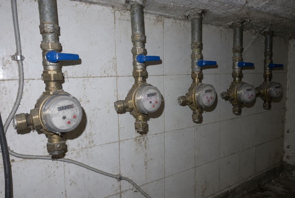 Batería de contadores de agua en el cuarto de contadores de un edificio de viviendas