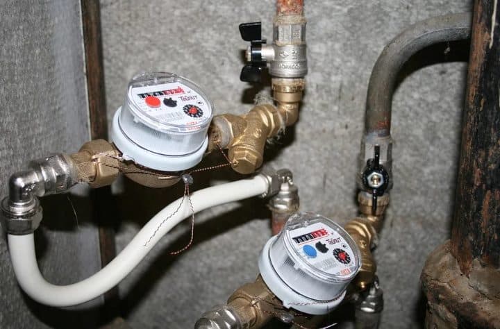 Contadores de agua y llaves de paso en un cuarto de contadores
